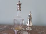 a bottle and a salt shaker sitting on a table