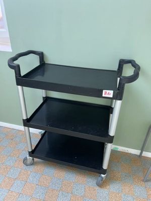 un chariot noir à deux étagères, dans un coin de la pièce