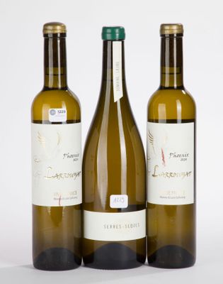 trois bouteilles de vin posées les unes à côté des autres sur une surface blanche