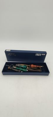 an image of a pen in a blue box on a white surface