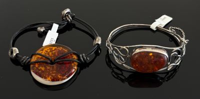 une paire de bracelets en argent et ambre sur un fond noir