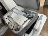 an open suitcase with electronics in it sitting on a table