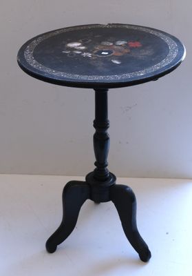 a small black table with a flower design on it