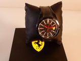 une montre posée sur un oreiller orné du logo Ferrari