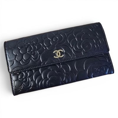 a close up of a black purse on a white surface