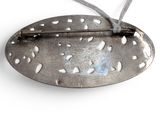 a metal object with holes on it on a white surface