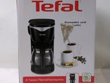 a box with a coffee maker and a cup of coffee