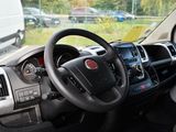 a steering wheel and dashboard of a truck in a parking lot