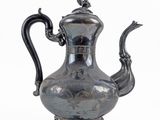 a silver tea pot on a stand on a white background
