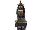 statue d'un samouraï assis sur une chaise en bois