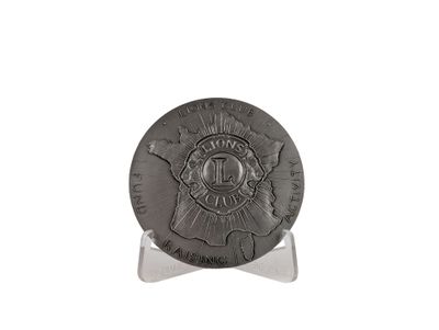 a close up of a coin on a stand on a white surface