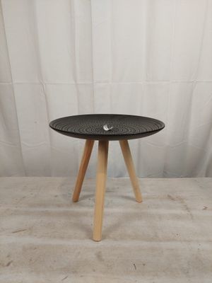 une petite table noire aux pieds en bois sur fond blanc