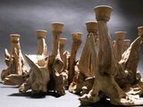 a group of vases made out of drift wood on a table