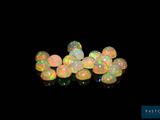 some white oplites on a black surface with a black background