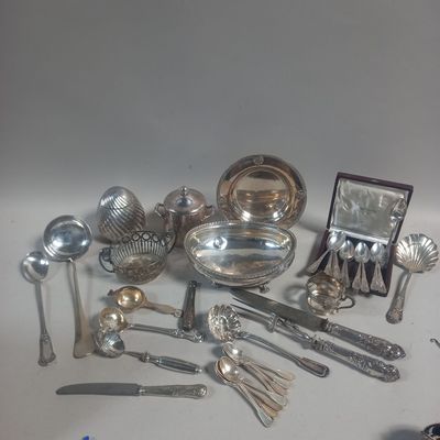a lot of silver spoons and other silverware on a table