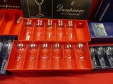 many empty wine glasses and spoons in a box