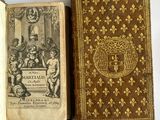 an old book sitting on top of a table next to an open book