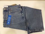 two pairs of blue jeans sitting on top of a white table