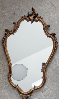 un miroir accroché au mur à côté d'un autre miroir