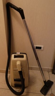 un aspirateur posé sur le sol à côté d'un mur