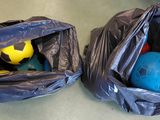 deux sacs posés par terre, contenant des balles