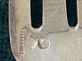 a silver plate with a fork on it on a green surface