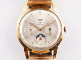 a gold wrist watch with a white dial on it