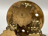 a close up of a gold colored metal object on a white surface