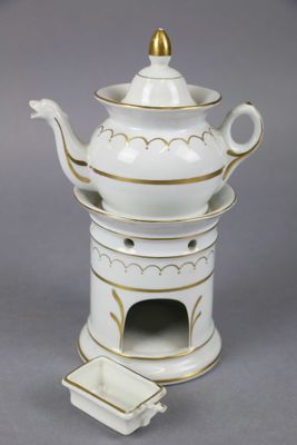 une théière blanche et dorée avec un couvercle doré
