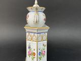 an image of a white and blue vase with a bird on top