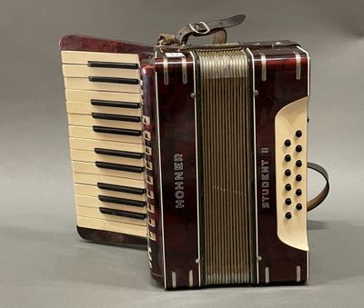 an old accordion sitting on top of a table next to a bag of luggage