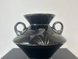 a black vase sitting on top of a black table