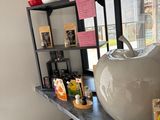 a white vase sitting on top of a counter next to a window