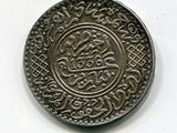 une vieille pièce d'argent comportant un motif sur un fond blanc