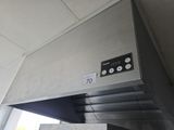 une image représentant une hotte de cuisine en acier inoxydable sur laquelle figure une horloge