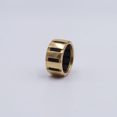 un gros plan d'une bague en or ornée de rayures noires
