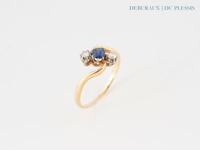gros plan d'une bague en or avec un saphir et des diamants