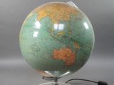 un globe vert posé sur un socle argenté, muni d'un cordon noir