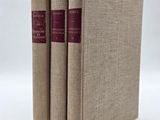 trois livres superposés sur une surface blanche