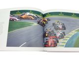 an open book with a picture of a race track and cars