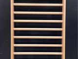 a wooden rack that is leaning against a black wall