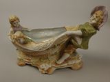 a figurine of a boy and a girl sitting in a boat