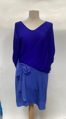 purple and blue dress on a mannequin stand in front of a white wall