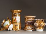 a lot of gold and white vases sitting on a table