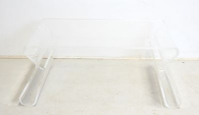 clear acrylic coffee table with two legs and a glass top