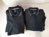 two black polo shirts sitting on top of each other on a table