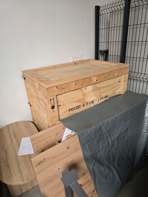 une boîte en bois posée sur une table à côté d'une chaise