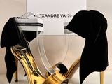 une paire de chaussures à talons hauts noires et dorées ornées d'un nœud papillon noir
