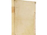 an old book is sitting on a white surface