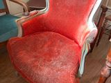 a red chair that is sitting on a wooden floor